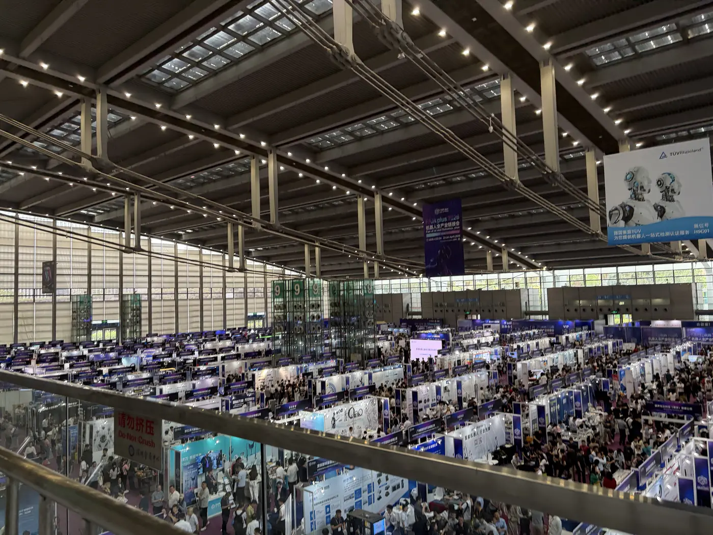 Crowded technology fair aisle observed during a field mission