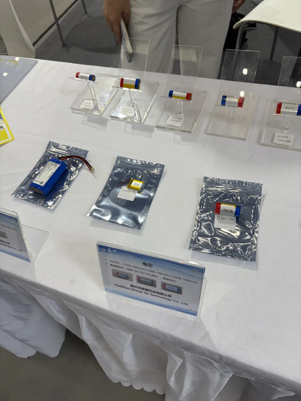 Battery cell samples packed in antistatic bags at a supplier booth