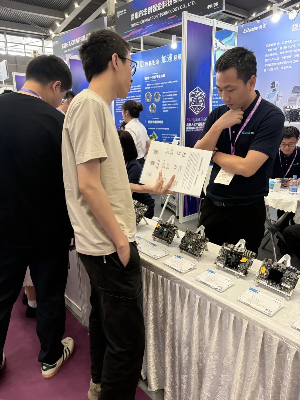 Exhibitor presenting a spec sheet, samples lined up on the table