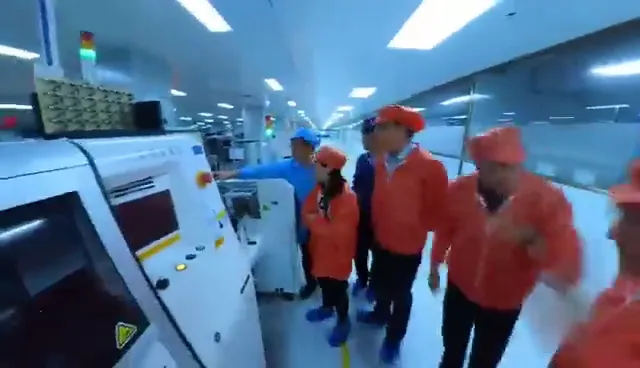 SMT placement line inside a supplier plant, operator in workwear